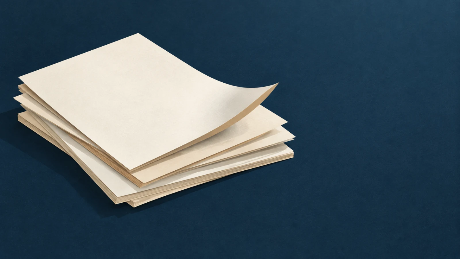 A stack of paper sheets on a deep navy surface